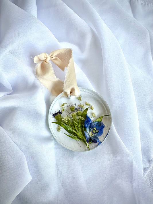 Shows a handcrafted resin ornament with bridal flowers preserved inside