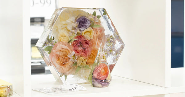 Hexagon resin keepsake and ornament with preserved peach, coral, and purple wedding flowers displayed on a shelf at Everlasting Bloom Co.