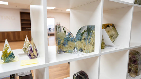 Display of finished resin flower keepsakes including bookends, ring holders, and floral blocks preserving real wedding bouquet flowers.