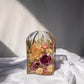 Resin flower preservation in a small arch mold, featuring dried bouquet blooms in a standing display.
