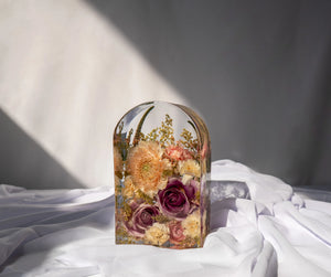 Resin flower preservation in a small arch mold, featuring dried bouquet blooms in a standing display.