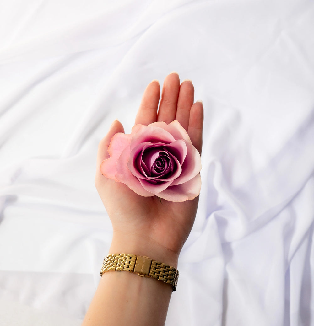 Top-down view of a dried wedding flower held in hand, demonstrating the preservation process using silica drying sand