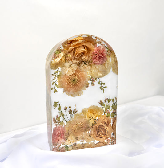 Close-up of a large arch resin keepsake with dried florals from a wedding bouquet.