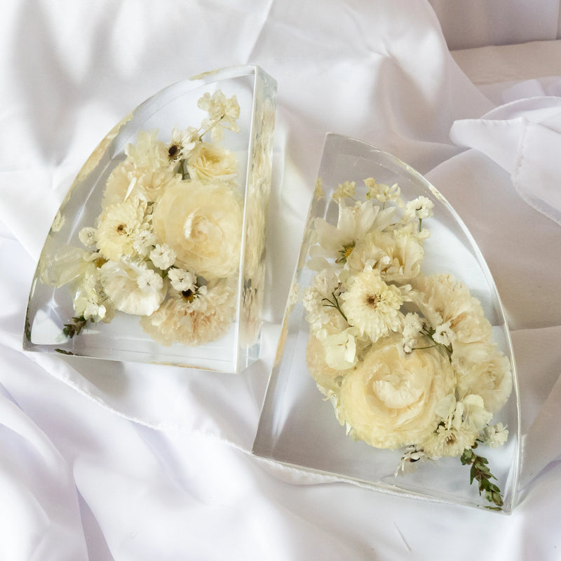 Set of clear resin bookends featuring preserved white and cream wedding flowers arranged in a modern curved design — handcrafted floral preservation by Everlasting Bloom Co.