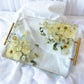 Rectangular resin tray with gold handles featuring preserved white and cream wedding flowers arranged in a clear, elegant display — handcrafted floral preservation by Everlasting Bloom Co.