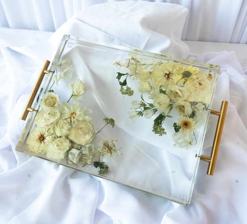 Rectangular resin tray with gold handles featuring preserved white and cream wedding flowers arranged in a clear, elegant display — handcrafted floral preservation by Everlasting Bloom Co.