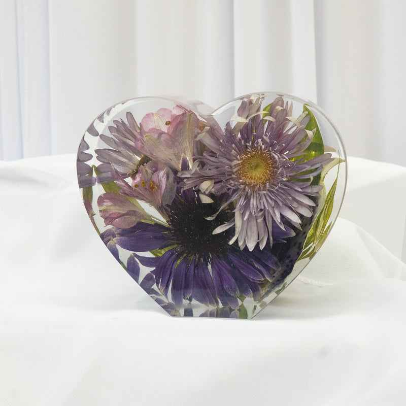 Heart-shaped resin block featuring preserved purple and lavender wedding flowers with soft greenery, arranged in a clear handcrafted display — floral preservation by Everlasting Bloom Co.