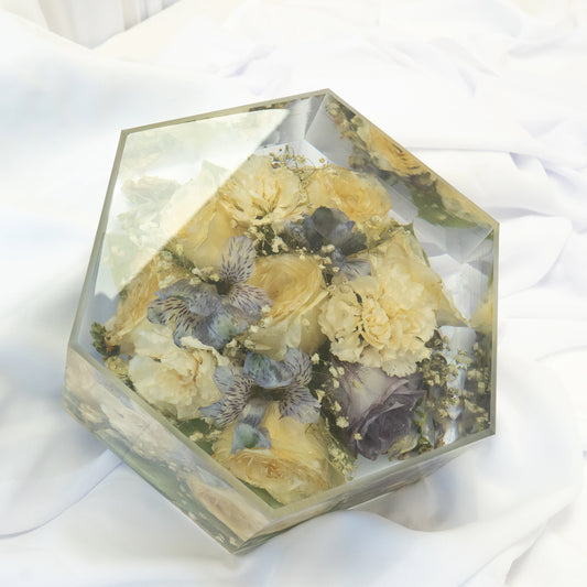 Hexagon-shaped resin block featuring preserved yellow roses, cream florals, and soft blue blooms arranged in a clear, handcrafted display — wedding flower preservation by Everlasting Bloom Co.
