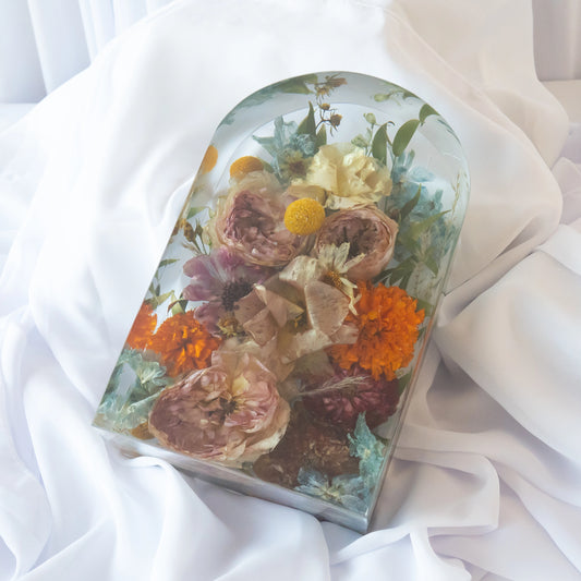 Large arch-shaped resin block featuring preserved roses, marigolds, and mixed colorful wedding flowers, arranged in a handcrafted clear display — floral preservation by Everlasting Bloom Co.