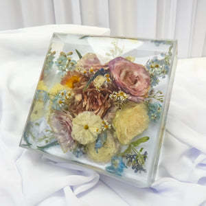 Crystal-clear floral block resin keepsake with preserved pink roses, blue flowers, and daisies from a wedding bouquet by Everlasting Bloom Co.