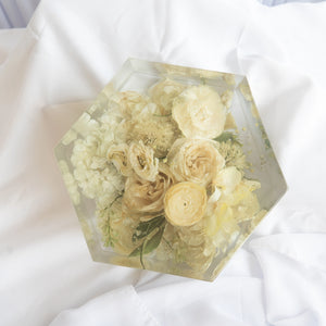 Hexagonal resin keepsake with preserved ivory roses, white hydrangea, cream ranunculus, and baby's breath from a wedding bouquet