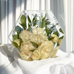 Hexagon resin flower preservation with white roses, ivory peonies, blue delphinium, and greenery — elegant custom bridal bouquet keepsake in clear epoxy