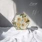Front-facing view of hexagon resin mold filled with dried flowers from a wedding bouquet.