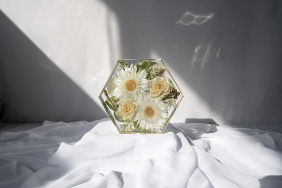 Front-facing view of hexagon resin mold filled with dried flowers from a wedding bouquet.