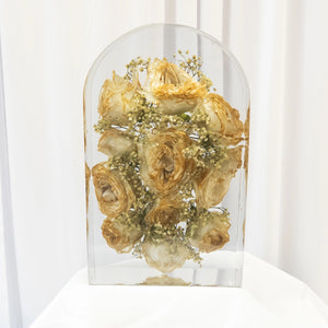 Large arch-shaped resin piece showing yellowed and discolored roses caused by delayed flower shipping, used as a comparison example