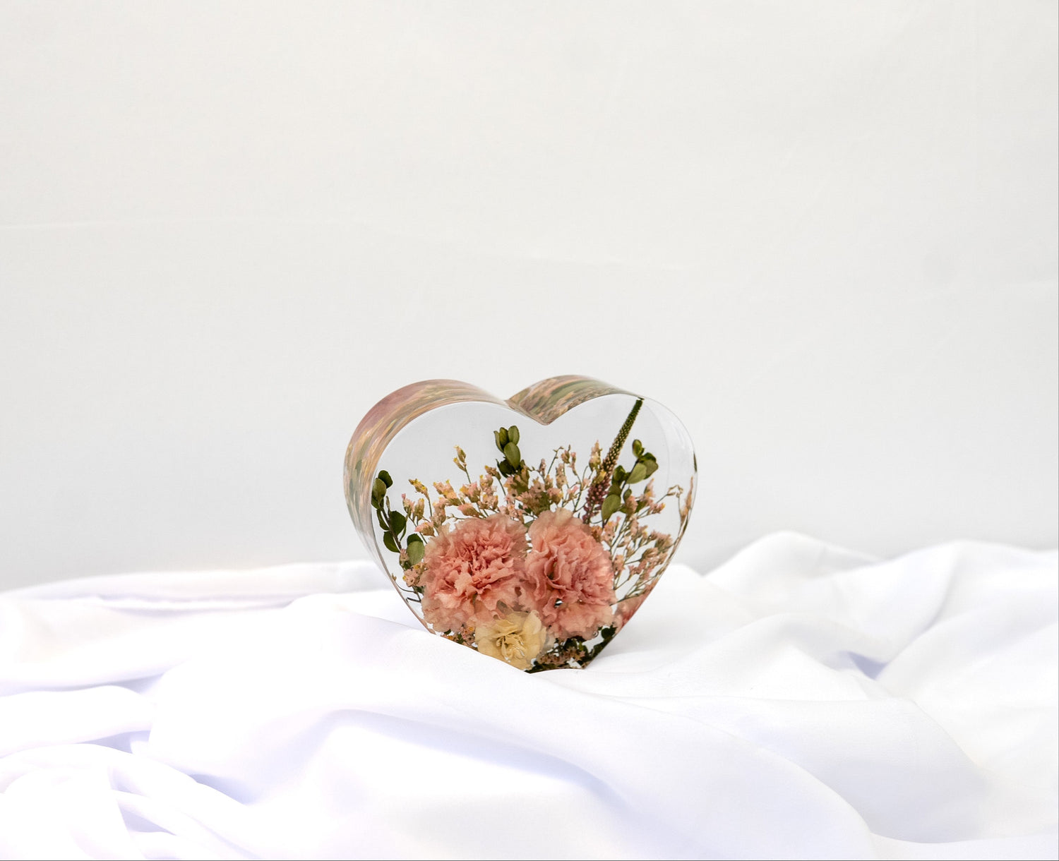Custom floral keepsake in a heart resin mold, preserving petals from a special occasion bouquet.