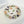 Octagonal clear resin jewelry dish with pressed greenery, leaves, and blush and deep purple flower petals around the rim.