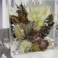 Panning video of an 8x8 resin flower preservation block featuring dried florals, pampas grass, preserved mauve rose, yellow strawflowers, feathers, and a butterfly — handmade memorial or wedding keepsake in clear epoxy