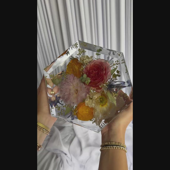 8-second video showcasing a hexagon-shaped resin keepsake made from real wedding flowers.