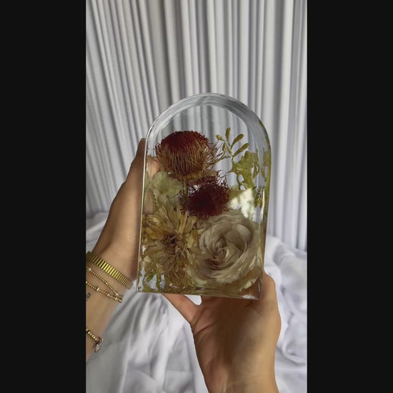 Video clip of a small arch-shaped resin piece preserving a bridal bouquet.