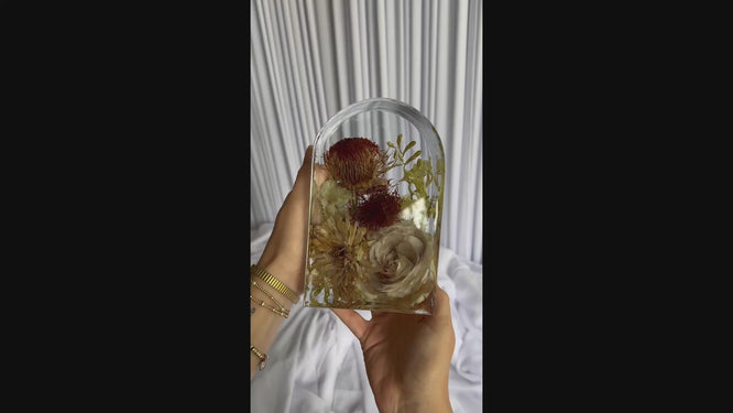 Video clip of a small arch-shaped resin piece preserving a bridal bouquet.