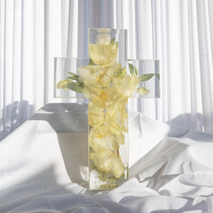 Clear resin cross keepsake with preserved soft yellow flowers and greenery from a wedding bouquet.