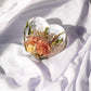 Heart-shaped resin keepsake showcasing real wedding flowers preserved in crystal-clear epoxy.