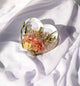 Heart-shaped resin keepsake showcasing real wedding flowers preserved in crystal-clear epoxy.