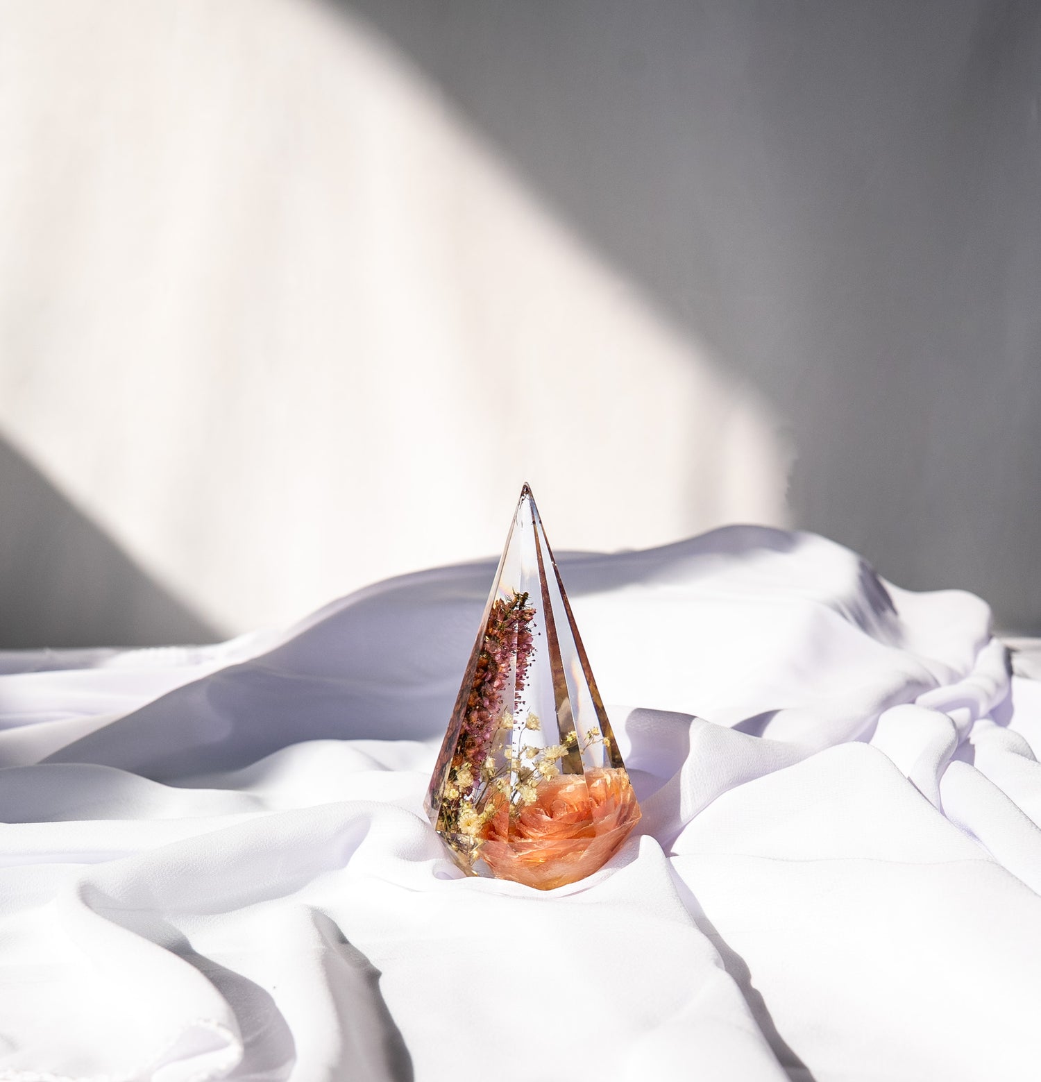 Head-on view of a resin ring holder keepsake made with preserved wedding flowers.