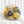 Standing circular resin display with preserved orange pincushion protea, yellow calla lily, deep purple strawflower, cream roses, and yellow craspedia from a wedding bouquet