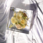 Top-down view of a square resin block showcasing vibrant preserved bouquet flowers.