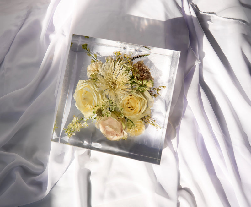 Top-down view of a square resin block showcasing vibrant preserved bouquet flowers.